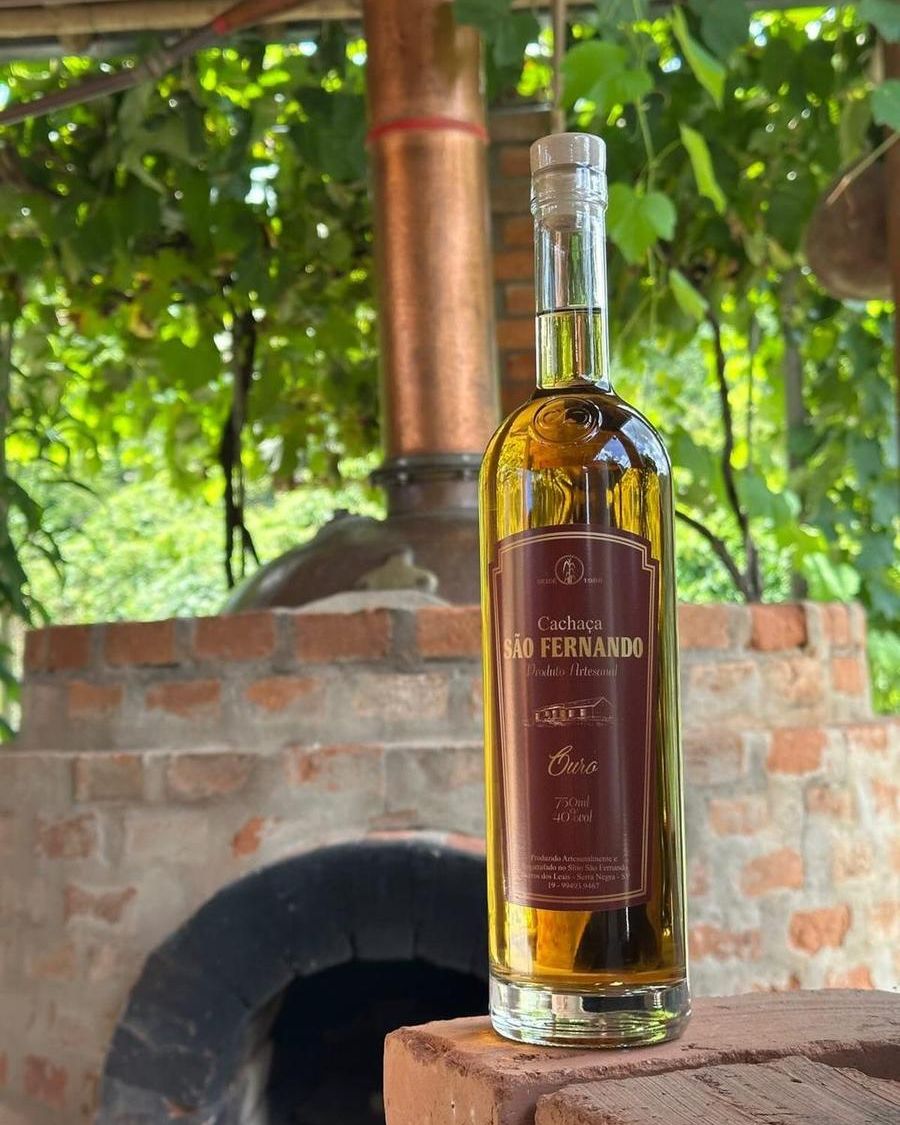 Garrafa de Cachaça Ouro São Fernando diante do forno de tijolos
