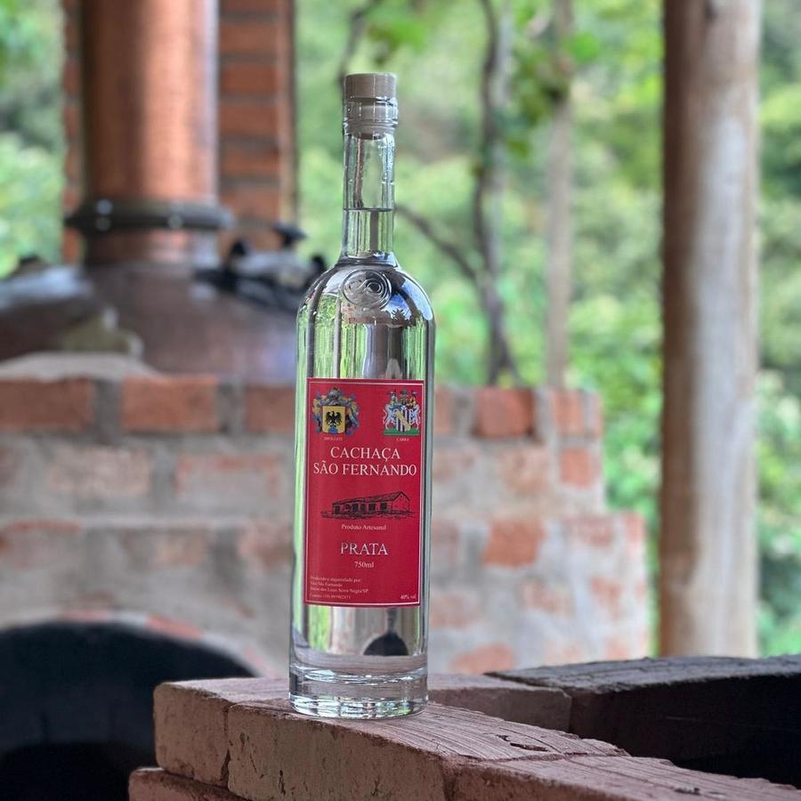 Garrafa de Cachaça Prata São Fernando diante do alambique