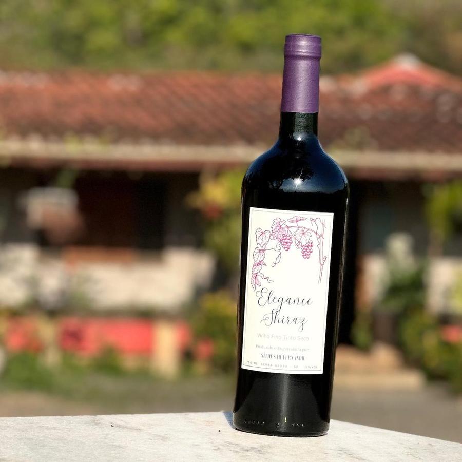 Garrafa de Elegance Shiraz com a casa do sítio ao fundo