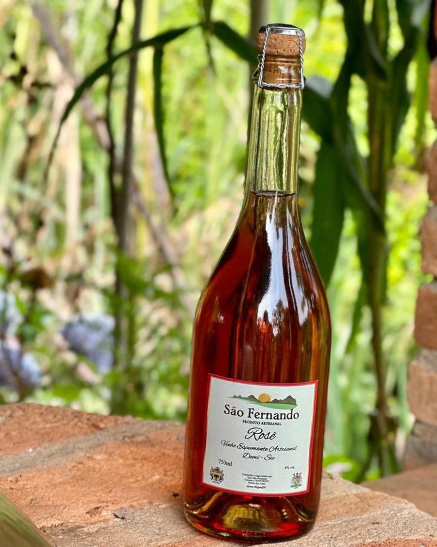Garrafa de Espumante Rosé Demi-sec sobre um muro de tijolos