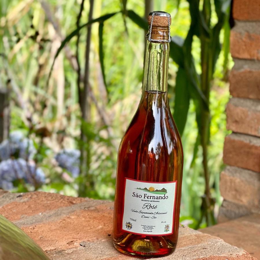 Garrafa de Espumante Rosé Demi-sec sobre um muro de tijolos