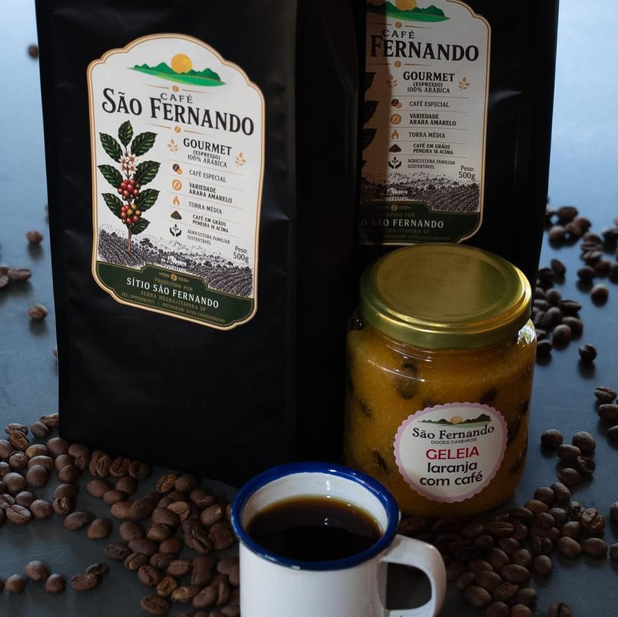 Pote de geleia de laranja com café ao lado de um pacote de café e grãos