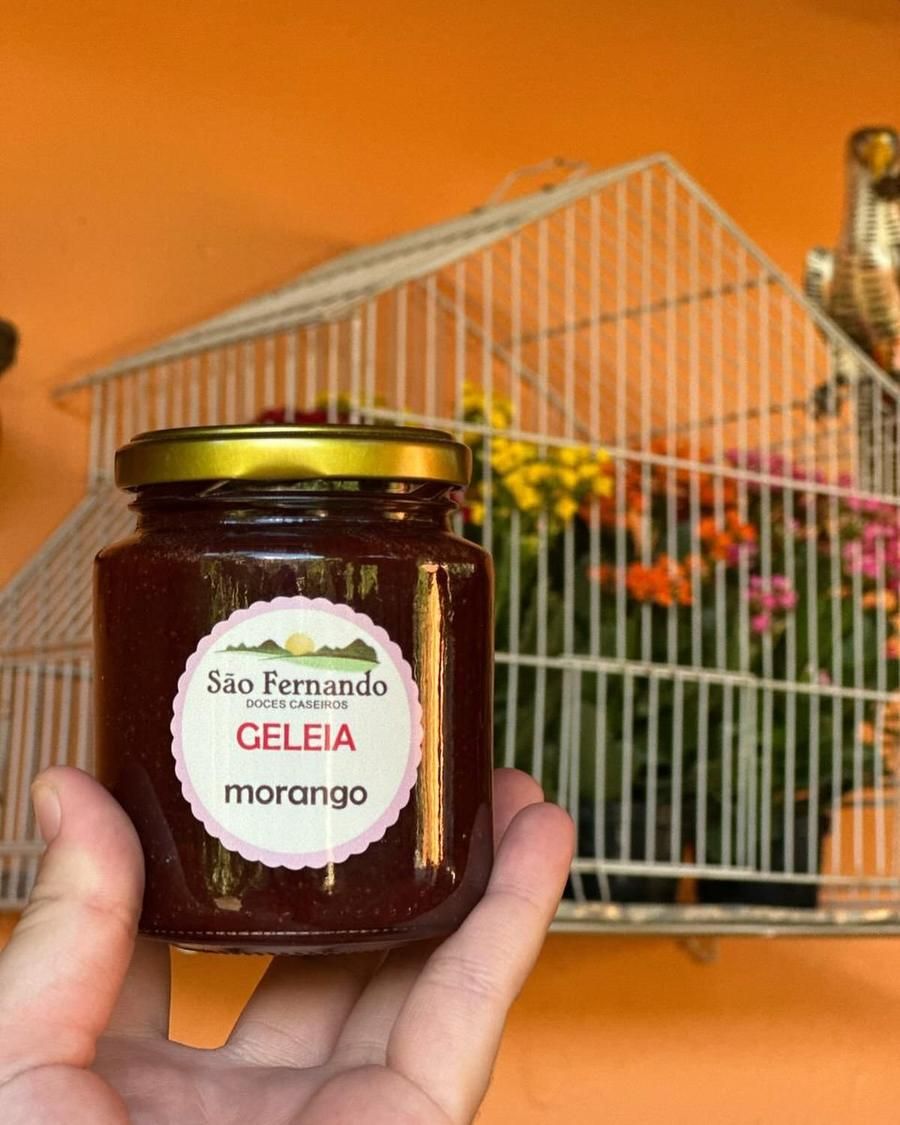 Mão segurando um pote de geleia de morango São Fernando